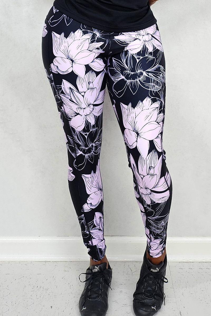 A woman wearing floral lavender and black tights, showcasing a stylish and versatile addition to her wardrobe that enhances her outfit with a bold pattern.