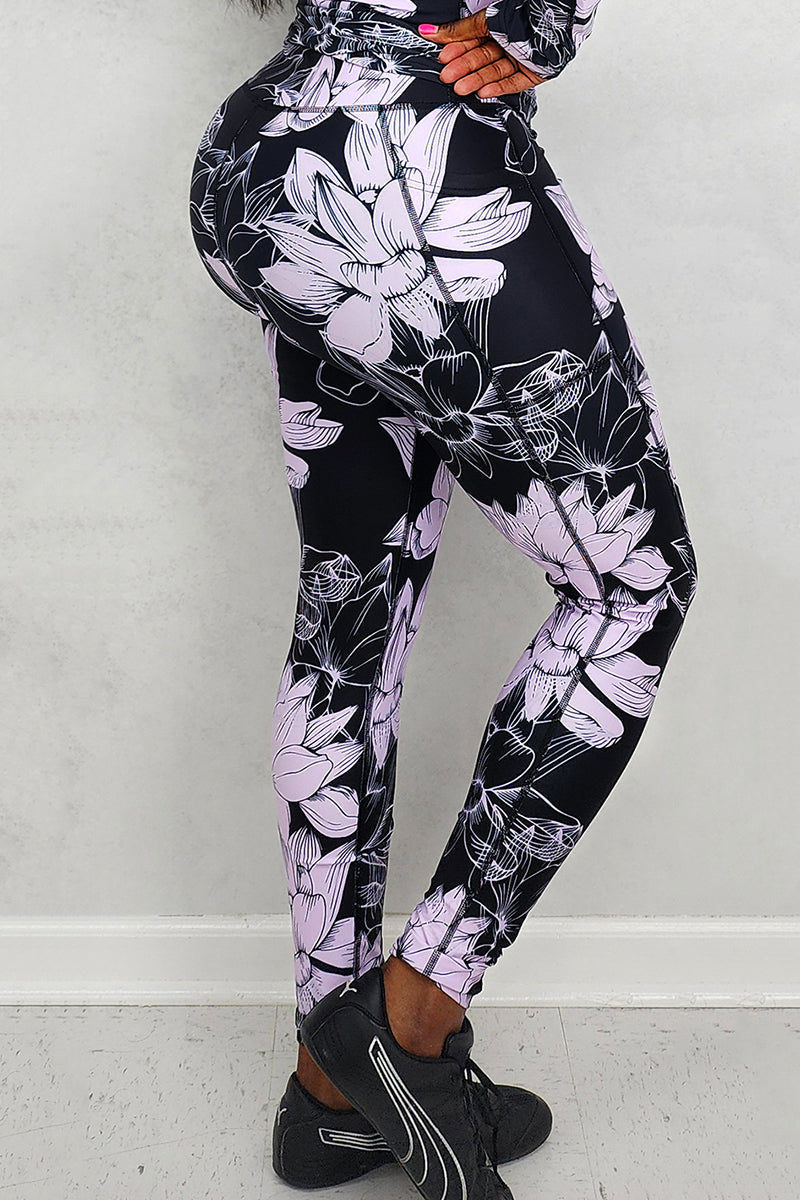 A woman wearing floral lavender and black tights, showcasing a stylish and versatile addition to her wardrobe that enhances her outfit with a bold pattern.