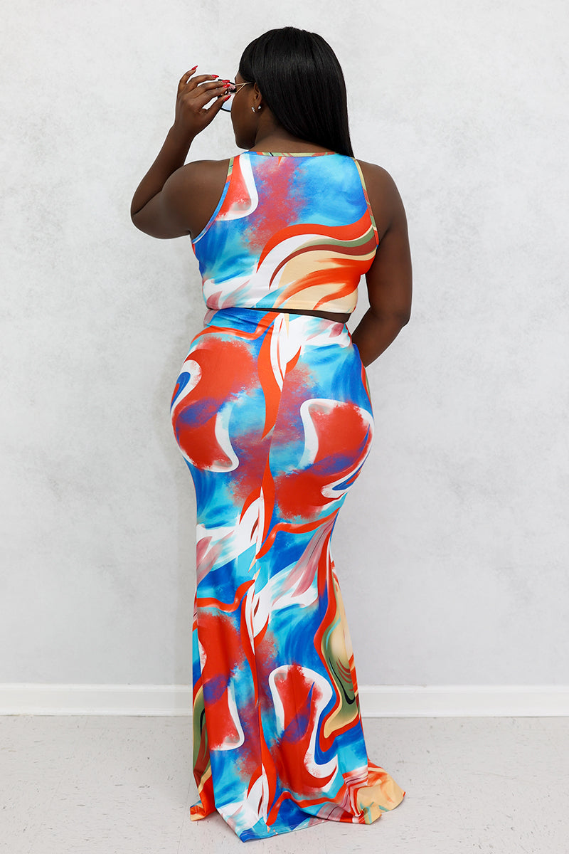 A woman wearing a high-waisted, multi-colored Mixed Print Skirt with a bold swirl design, stretchy fabric, and a drawstring for a comfortable fit.