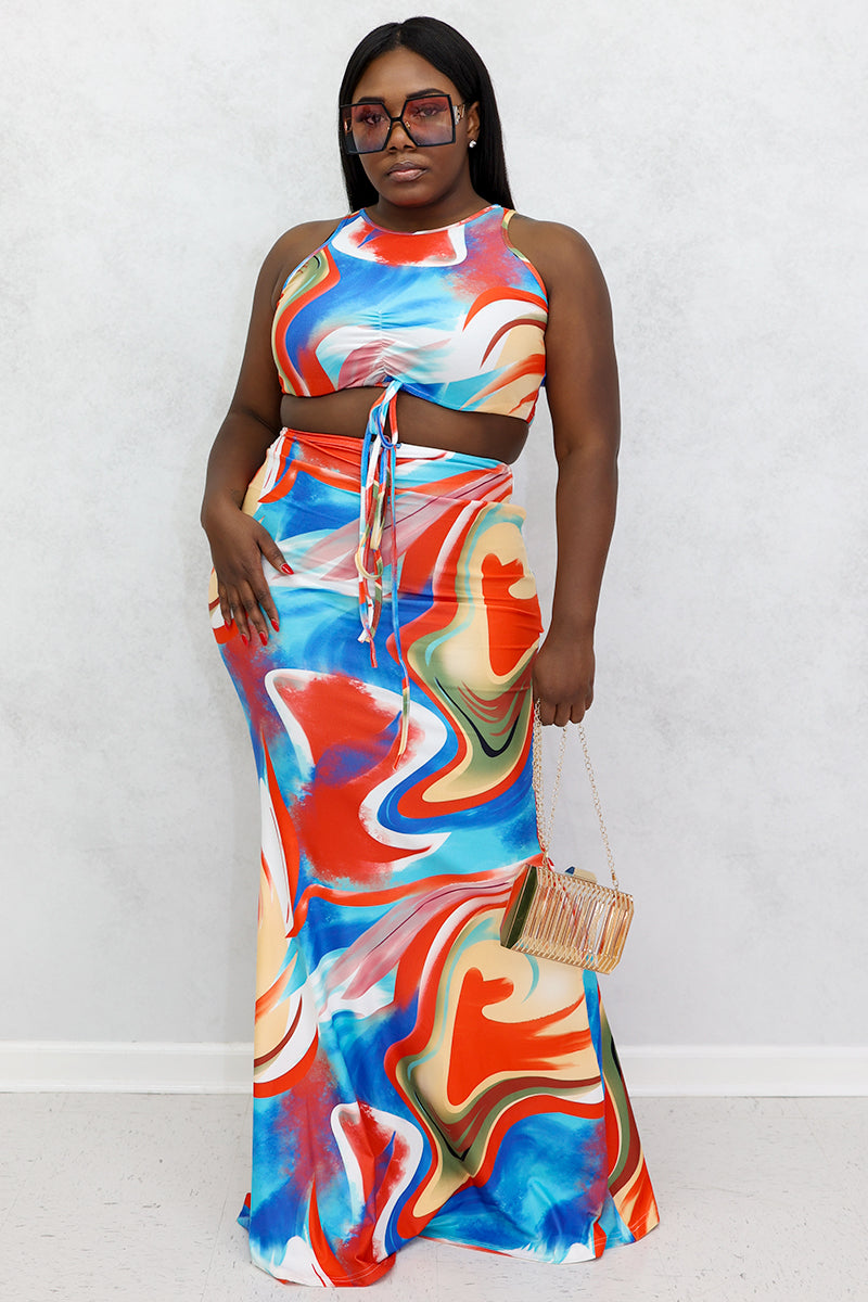 A woman wearing a high-waisted, multi-colored Mixed Print Skirt with a bold swirl design, stretchy fabric, and a drawstring for a comfortable fit.