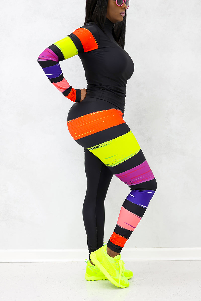 A woman wearing the Paint Strokes Tights in a vibrant multi-color design, featuring a pocket on the left thigh and a continuous drawstring, perfect for adding creativity to her workout routine.