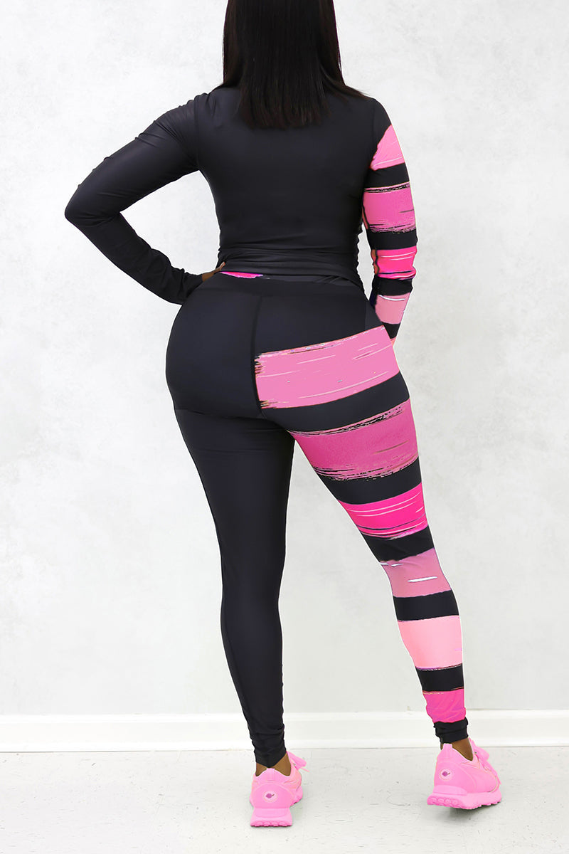 A woman wearing the Paint Strokes Limited Edition Tights in black and pink, featuring a pocket on the left thigh and a continuous drawstring, designed in support of National Breast Cancer Awareness Month.