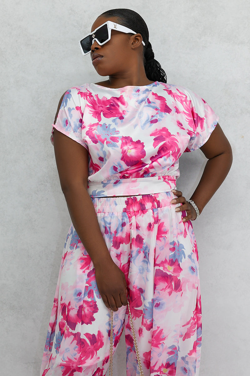 A woman wearing a Red Flower Open Back Crop Top featuring a delicate floral print, slit sleeves, and a stylish open back, perfect for adding flair to any outfit.