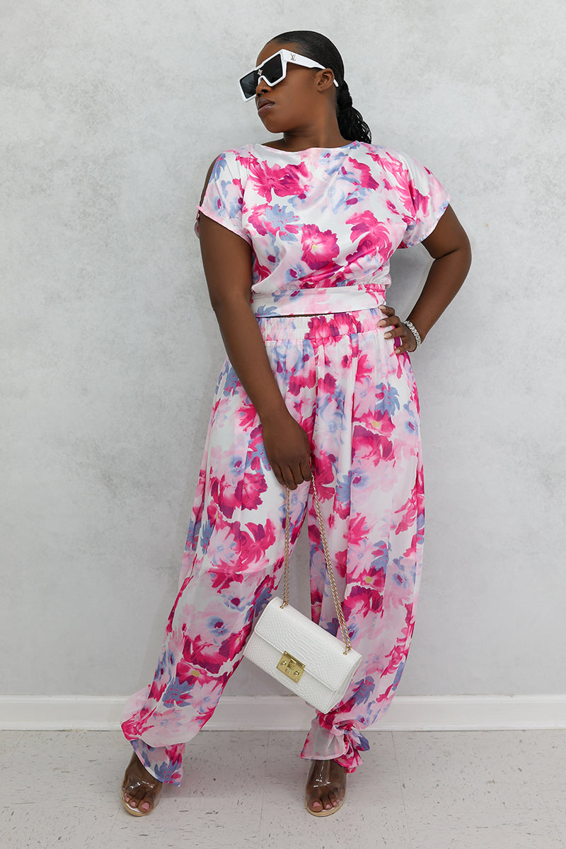 A woman wearing a Red Flower Open Back Crop Top featuring a delicate floral print, slit sleeves, and a stylish open back, perfect for adding flair to any outfit.