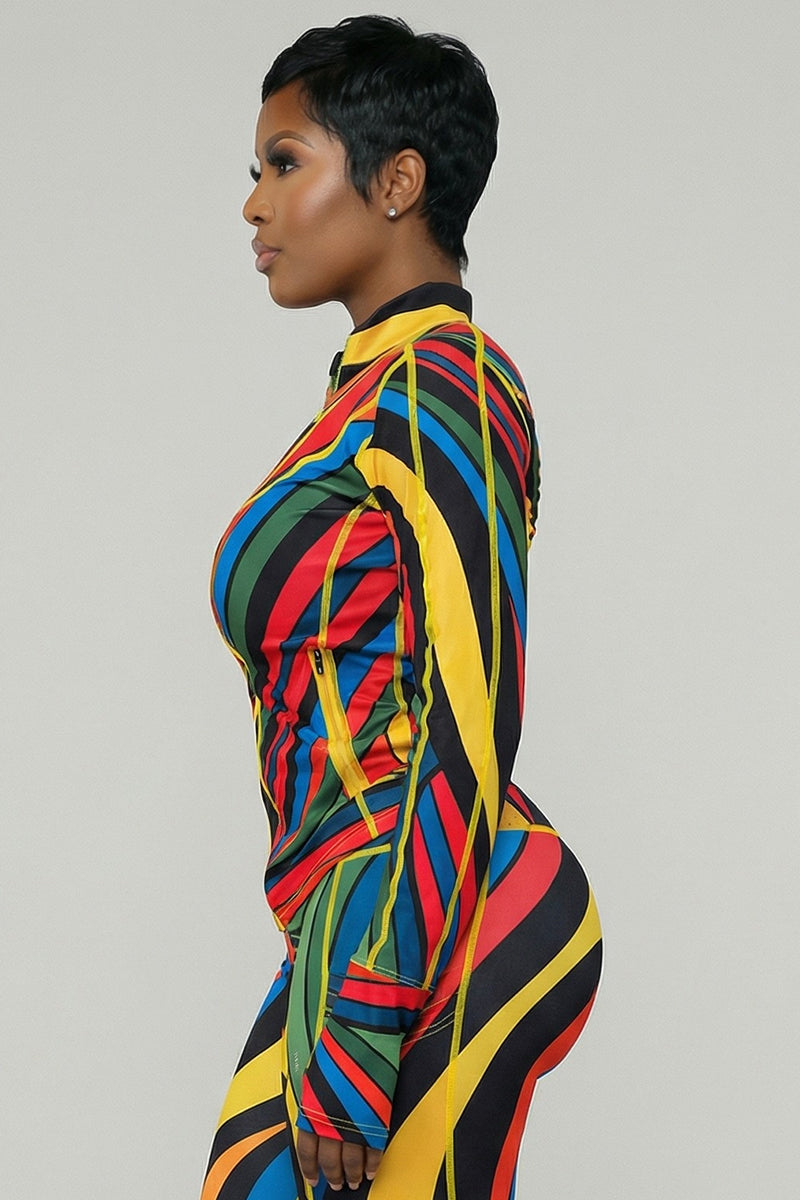 A person with short hair is shown in profile wearing the Color Riot Jacket in multi, a colorful, form-fitting piece with diagonal stripes and 4-way stretch for comfort. The background is plain and light gray.