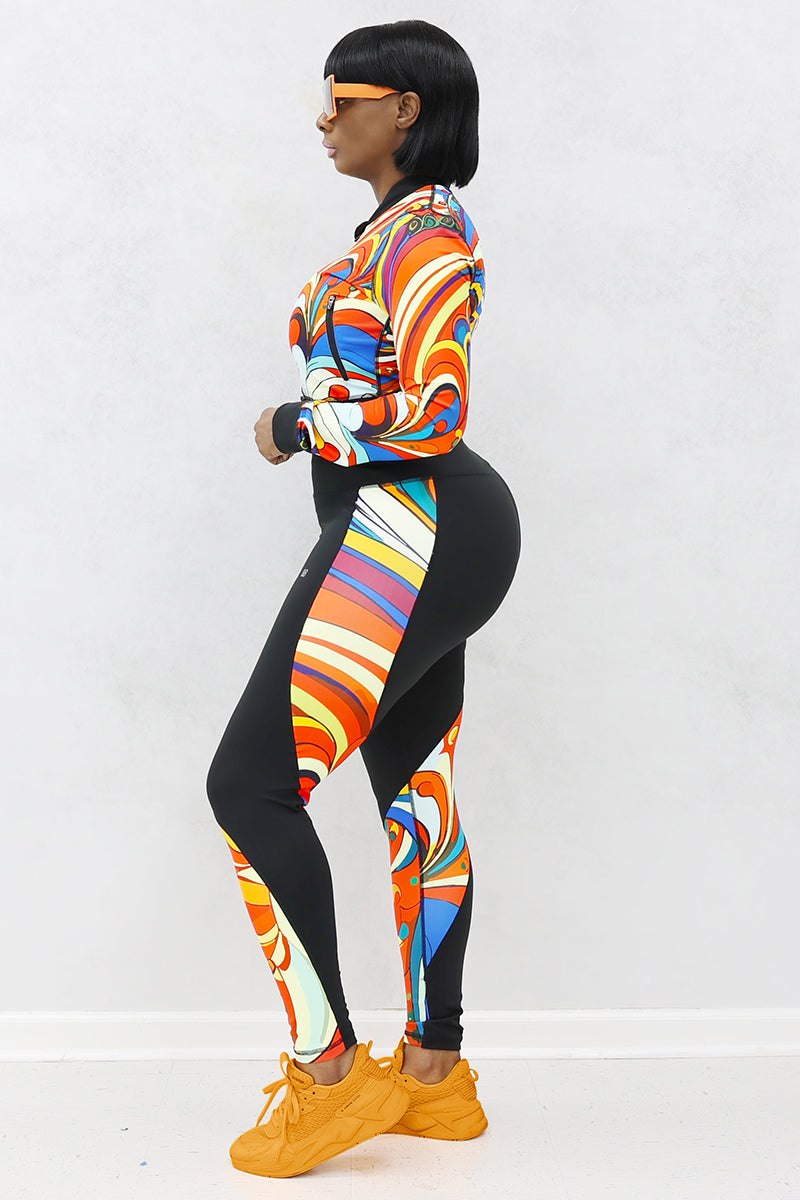 A woman wearing multi-colored Soul Train Tights featuring sleek black fabric with vibrant retro patterns, designed for comfort and performance during workouts or everyday activities.