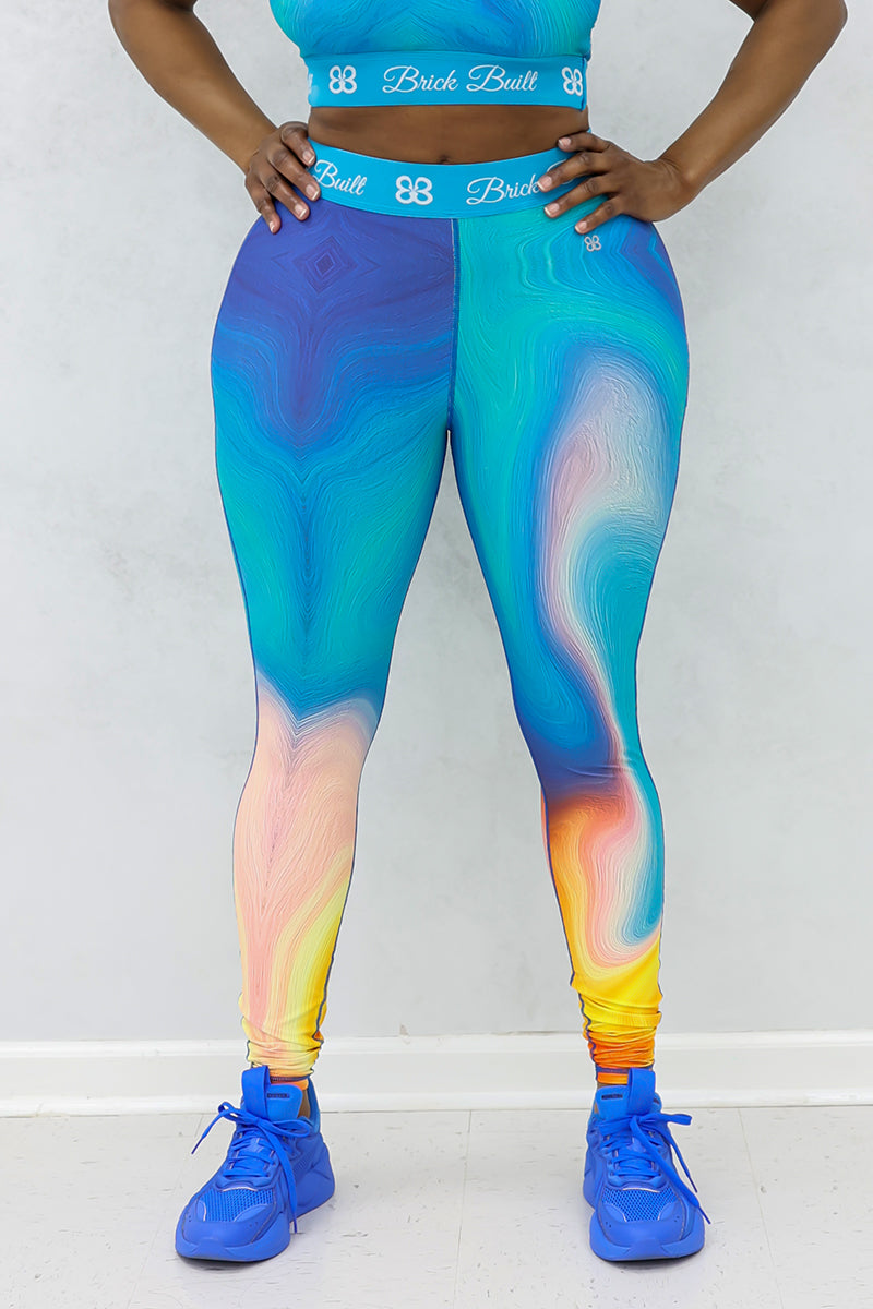 A woman wearing blue Spiral Training Tights, designed for flexibility and support, featuring a stretchy fit and an inside pocket for added functionality during workouts.