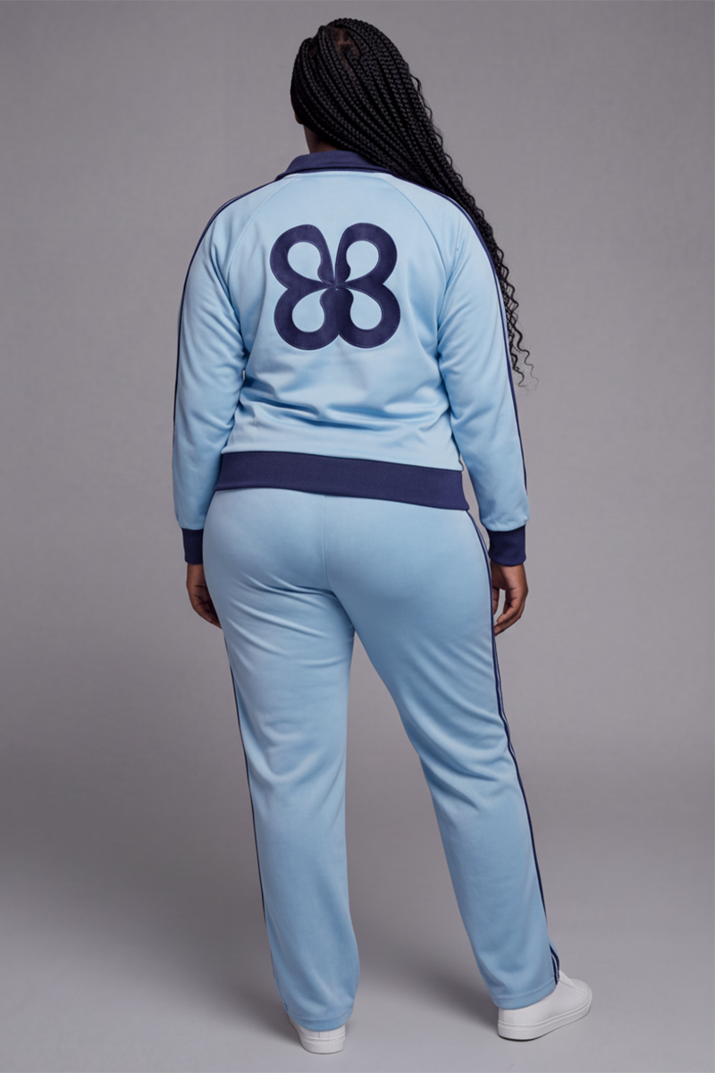 Back view of a light blue tracksuit with a large navy graphic on the jacket and navy side stripes on the pants.