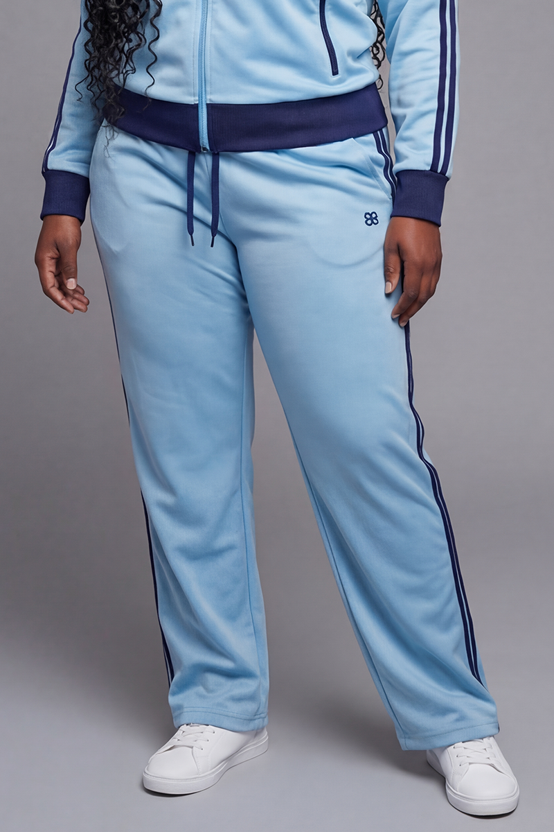 Light blue track pants with navy side stripes and a small navy logo near the pocket.