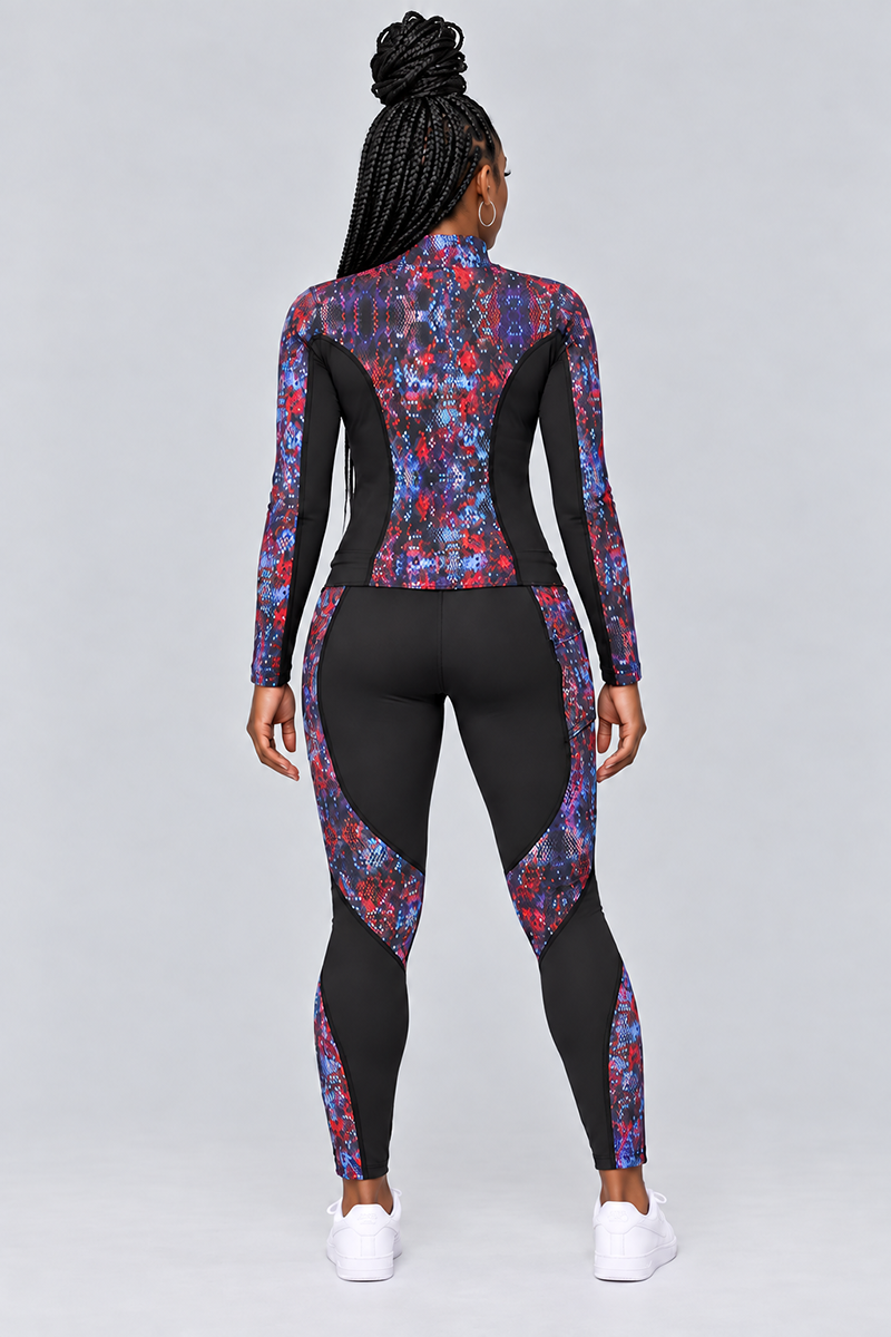 A person with long braids is standing facing away, wearing a black and colorful patterned athletic outfit featuring the Kario Tights—4-way stretch polyester spandex leggings with a body-contouring fit. The ensemble includes long sleeves and is paired with white sneakers. The background is plain and light gray.