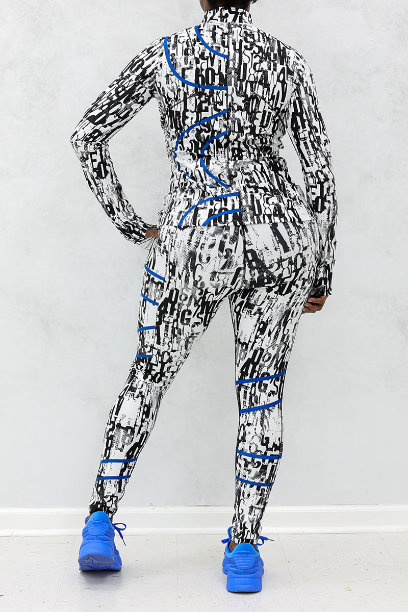 A person faces away from the camera wearing Blue Streak Tights—high-waisted black and white patterned leggings with blue accents—and matching sneakers, standing against a light gray wall and white floor.