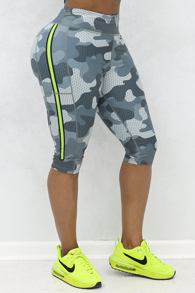 A woman wearing Grey and black camo capri pants with a trendy, casual design.