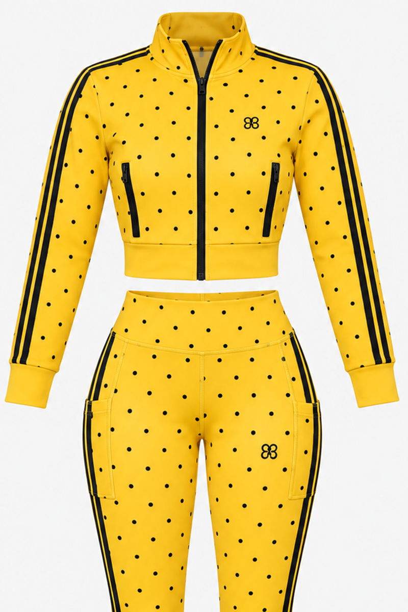 The Spotlight Jacket (SAMPLE SALE) in Yellow-Black features black polka dots, black stripes down the sleeves and legs, a zip-up cropped jacket, high-waisted pants, and a small black logo on both pieces—now available at a special discounted price as part of our exclusive sample sale.