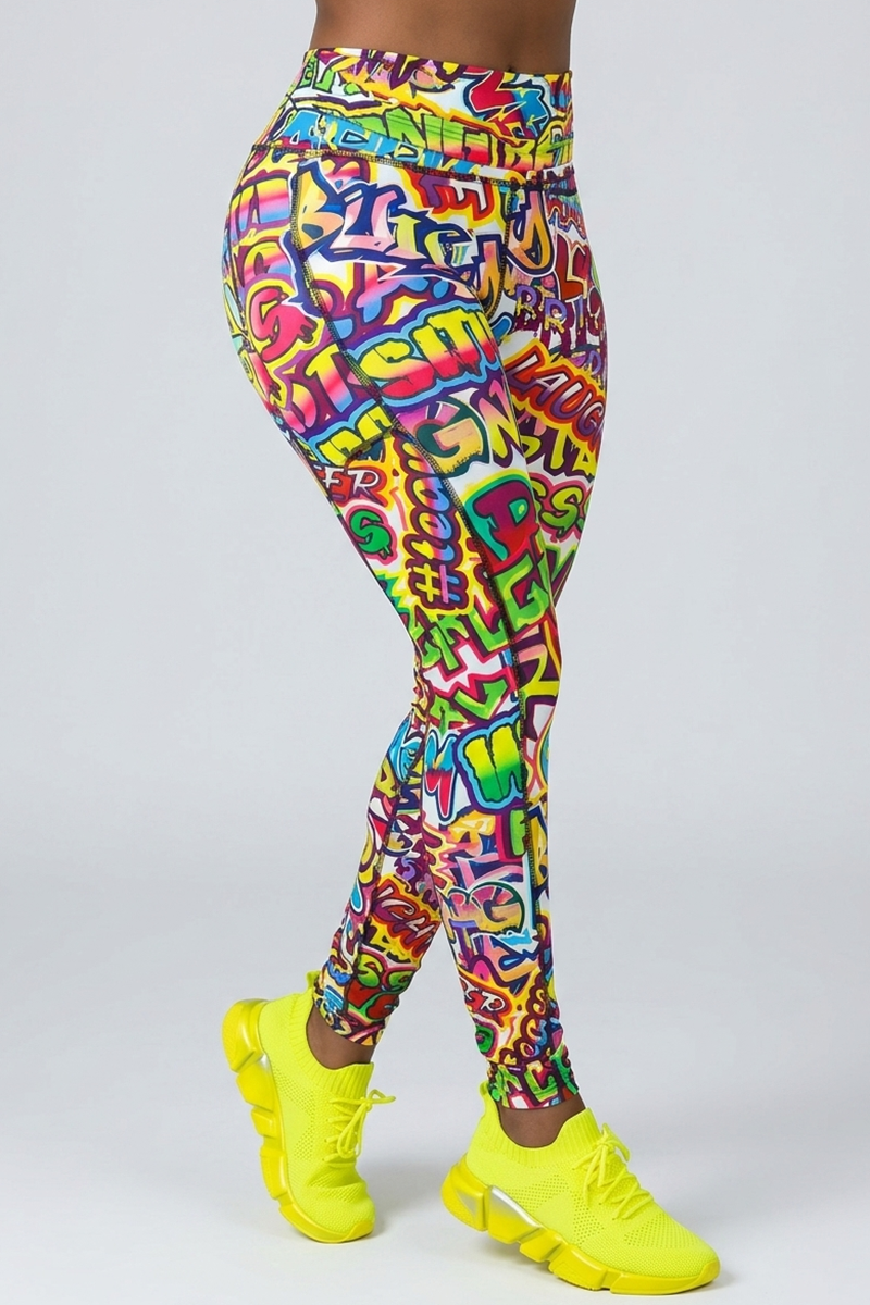 A person’s lower body is shown against a plain background, wearing Graffiti Tights and bright yellow athletic shoes.