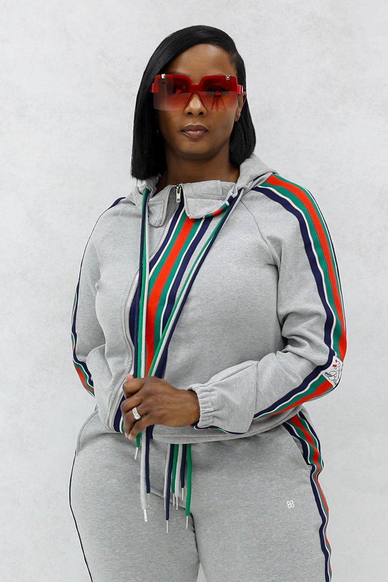 Woman wearing red sunglasses with a gray font stripe jacket with full front zipper