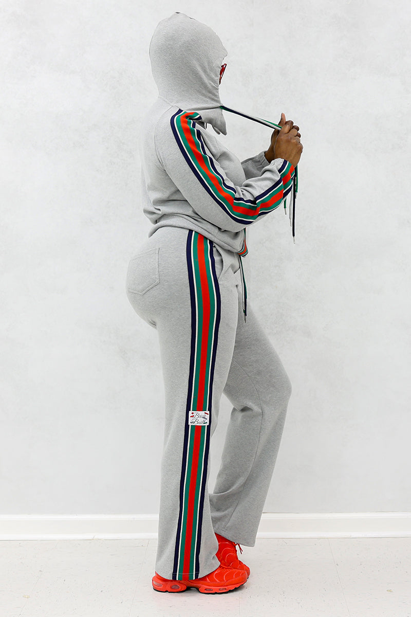 Woman wearing gray front stripe hooded jacket and side stripe joggers with pockets