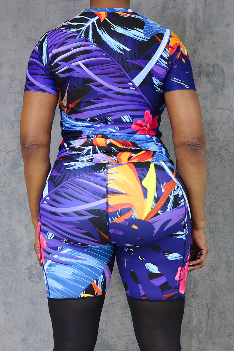 Colorful tropical print athletic t-shirt with floral and leaf patterns.
