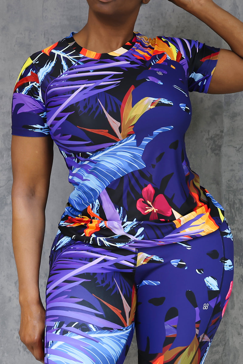 Colorful tropical print athletic t-shirt with floral and leaf patterns.
