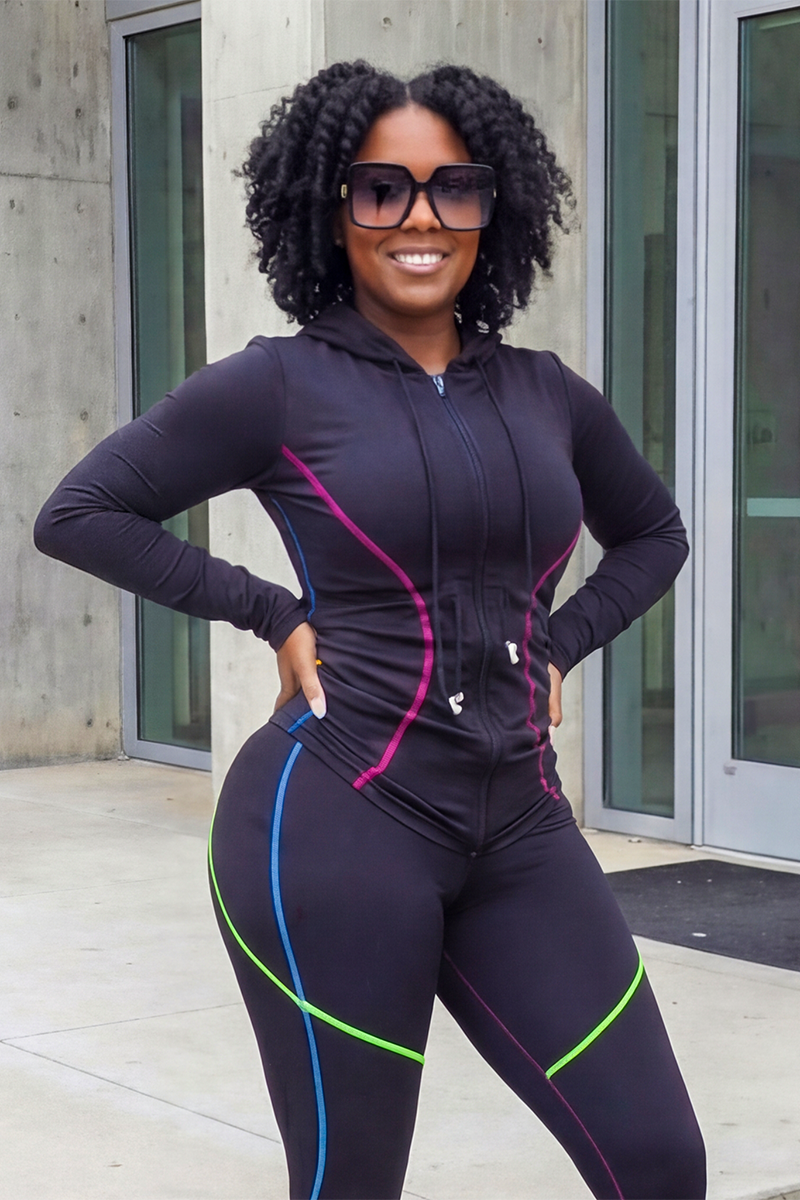 A woman smiles with her hands on her hips outdoors, wearing the Multi-Stitching Long Sleeve Jacket in a multi-color design.