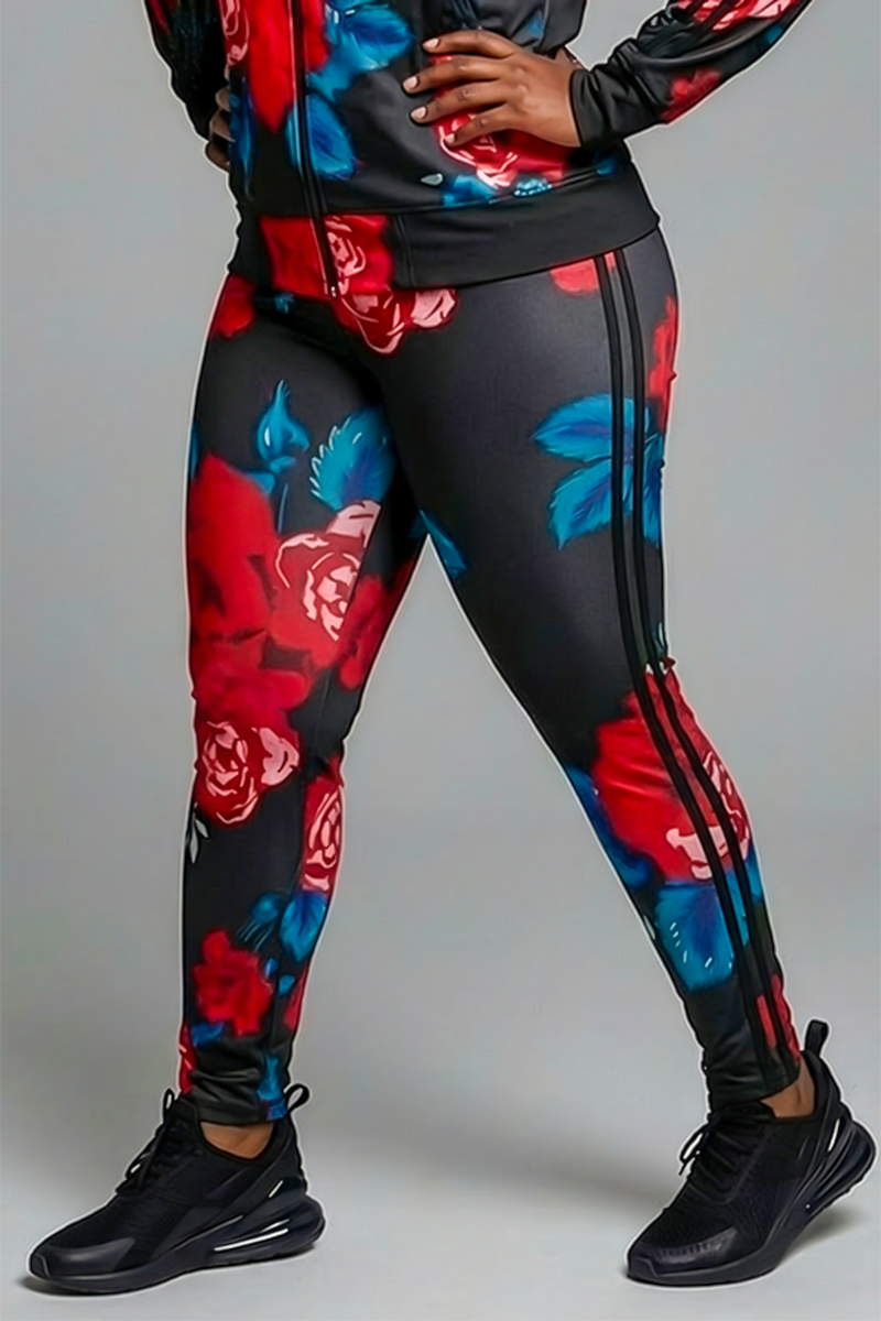 A person wears Red Roses Tights in Black-Red, paired with a matching jacket and black sneakers, standing with one hand on their hip against a plain gray background.