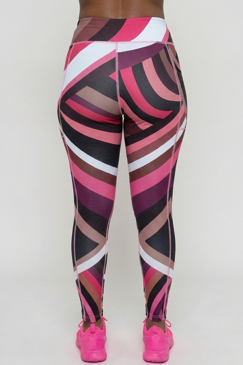 A person stands facing away, wearing Sable Tights featuring a pink, black, white, and brown geometric pattern. They are paired with bright pink sneakers against a plain light background.