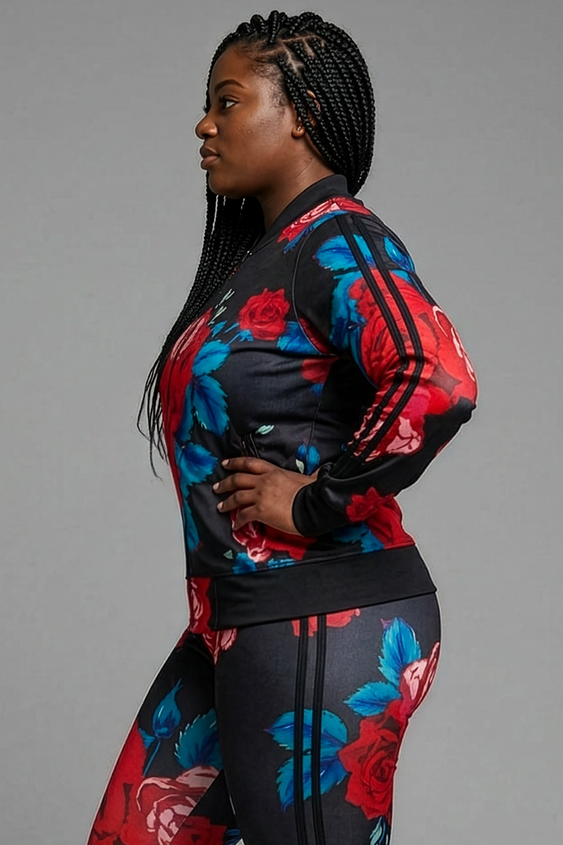 A woman stands in profile with one hand on her hip, modeling the Red Roses Jacket—a black athletic jacket made from stretchy polyester spandex with bold red and blue floral patterns—against a plain gray background.