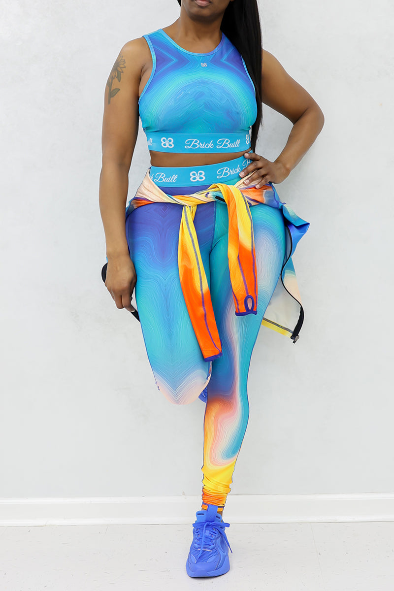 A woman wearing blue Spiral Training Tights, designed for flexibility and support, featuring a stretchy fit and an inside pocket for added functionality during workouts.