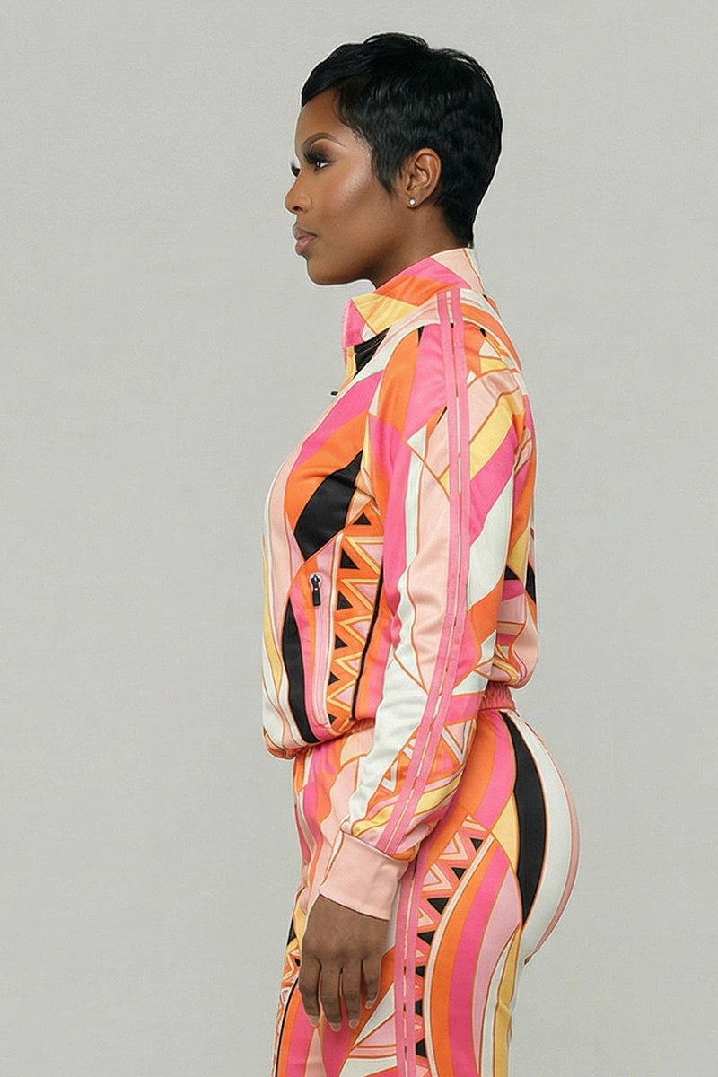 A woman in profile poses against a plain background, wearing the Vanta Leisure Jacket with matching pants—featuring a colorful geometric print in pink, orange, white, and black on stretchy polyester spandex for comfort.