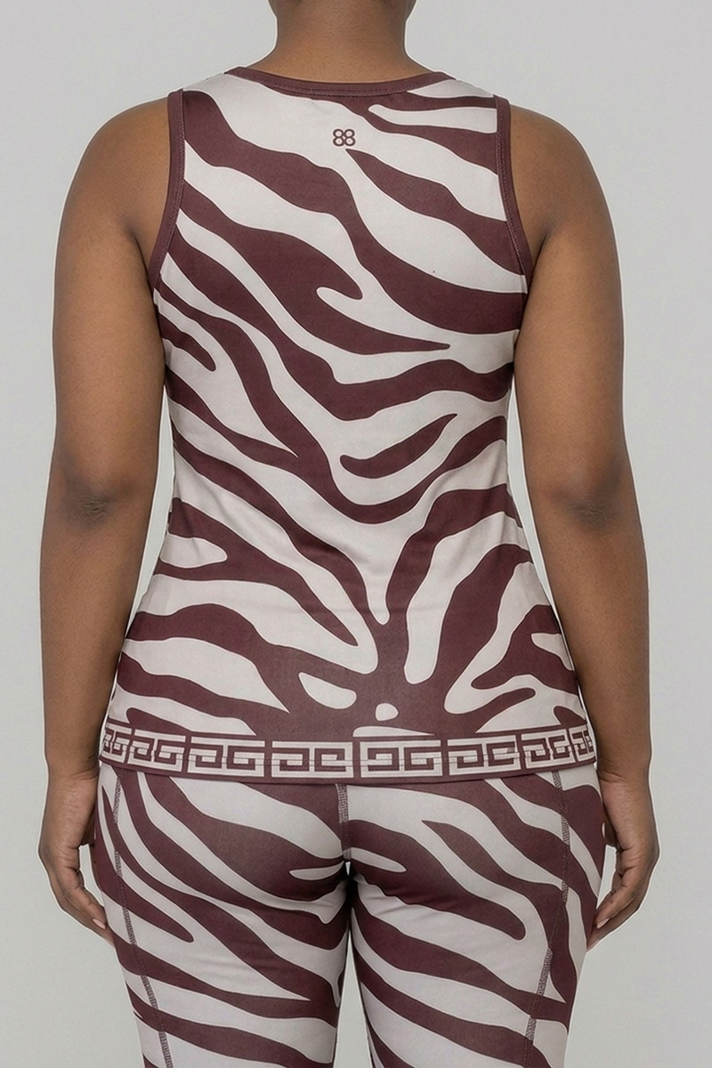 Back view of a woman wearing the matching brown and tan zebra print activewear set, showcasing the racerback-style tank top and the Greek key pattern waistband on the leggings.