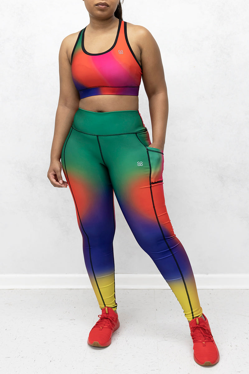 A beautiful woman wearing multi-colored Gradient Flow tights featuring a stylish gradient pattern for added flair.