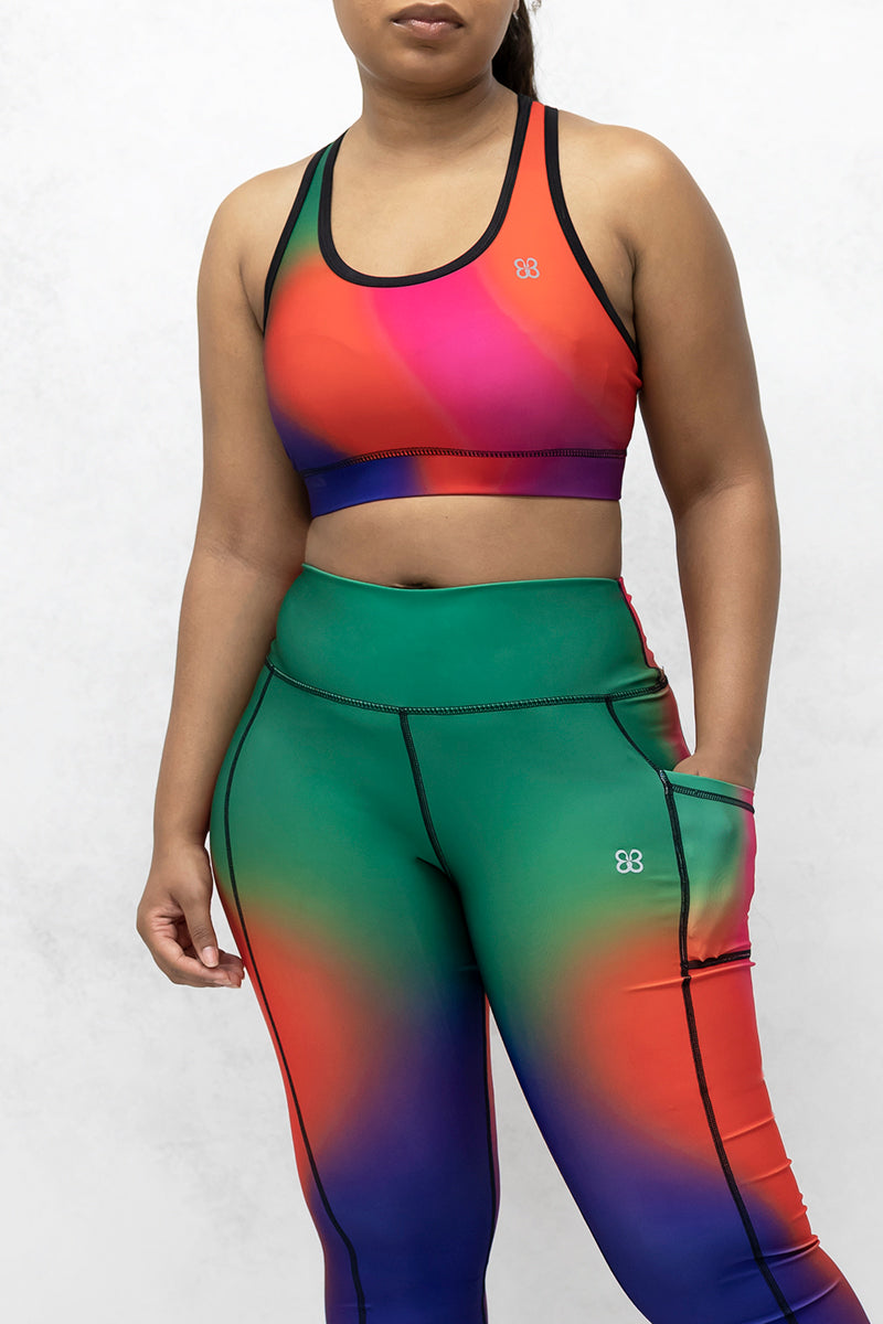 A beautiful woman wearing multi-colored Gradient Flow tights featuring a stylish gradient pattern for added flair.