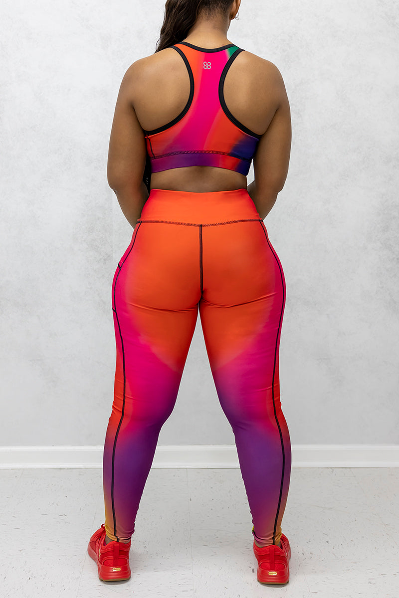 A beautiful woman wearing multi-colored Gradient Flow tights featuring a stylish gradient pattern for added flair.