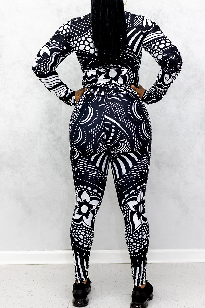 A woman wearing black and white Journey Tights, featuring a unique design, stretchy fabric, and pockets on both legs for added convenience.