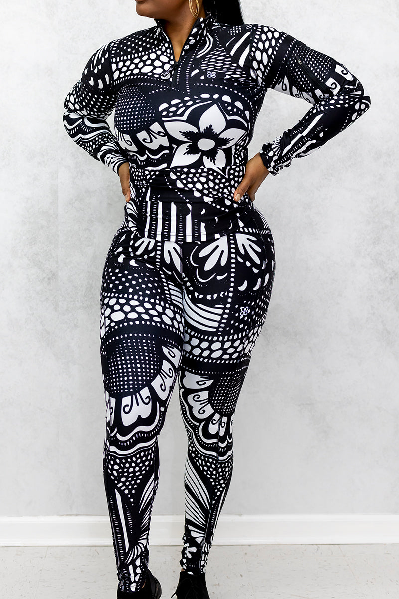 A woman wearing black and white Journey Tights, featuring a unique design, stretchy fabric, and pockets on both legs for added convenience.