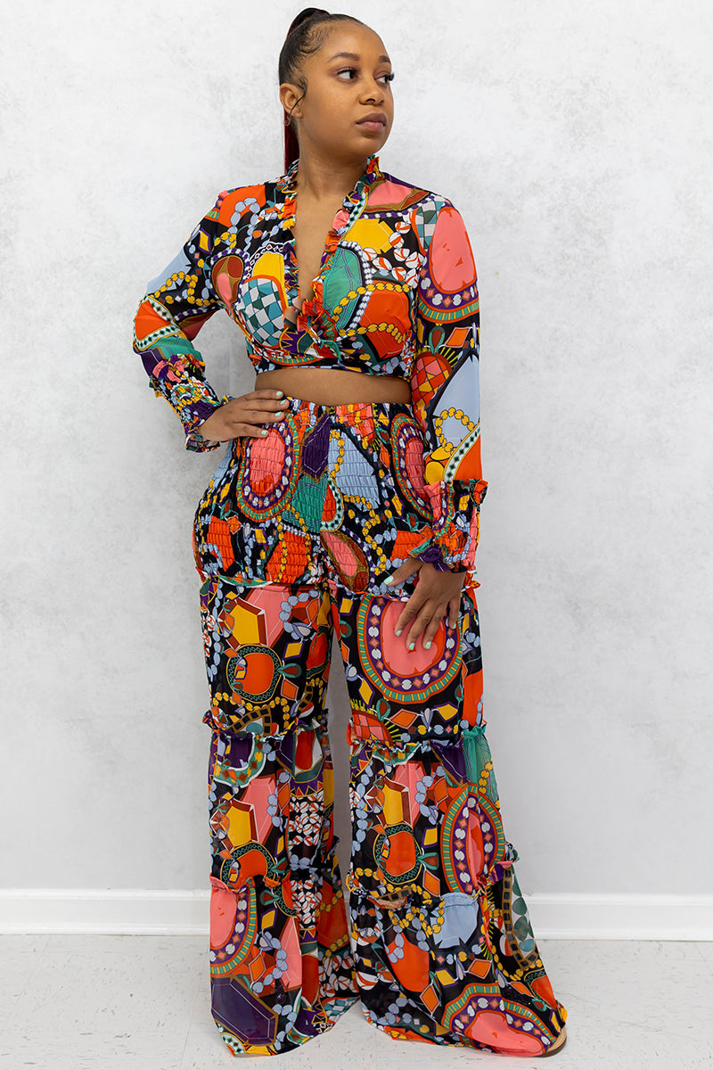 A woman wearing multi-colored Jewel Wide Leg Pants featuring a stylish jewel print and an elastic waistband, designed for comfort and flow.