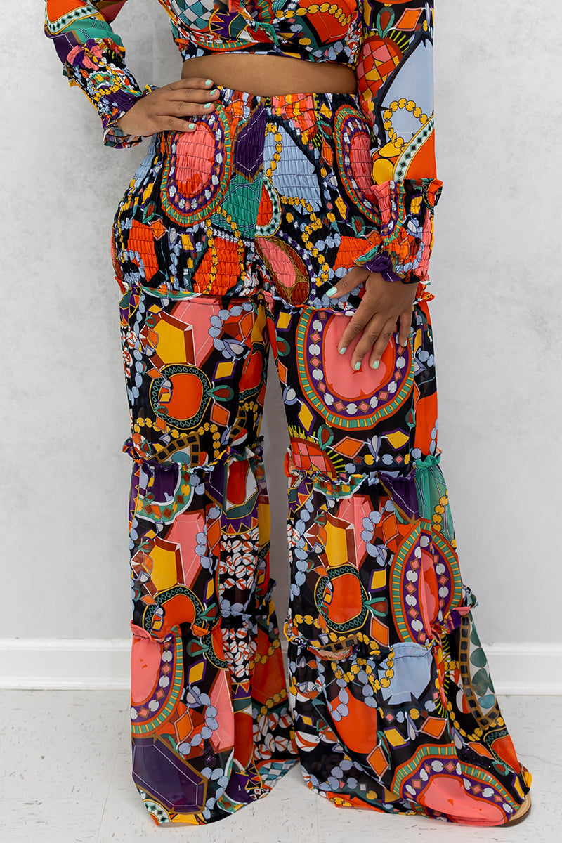 A woman wearing multi-colored Jewel Wide Leg Pants featuring a stylish jewel print and an elastic waistband, designed for comfort and flow.